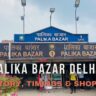 a group of people walking in front of palika bazar gate no. 1 delhi