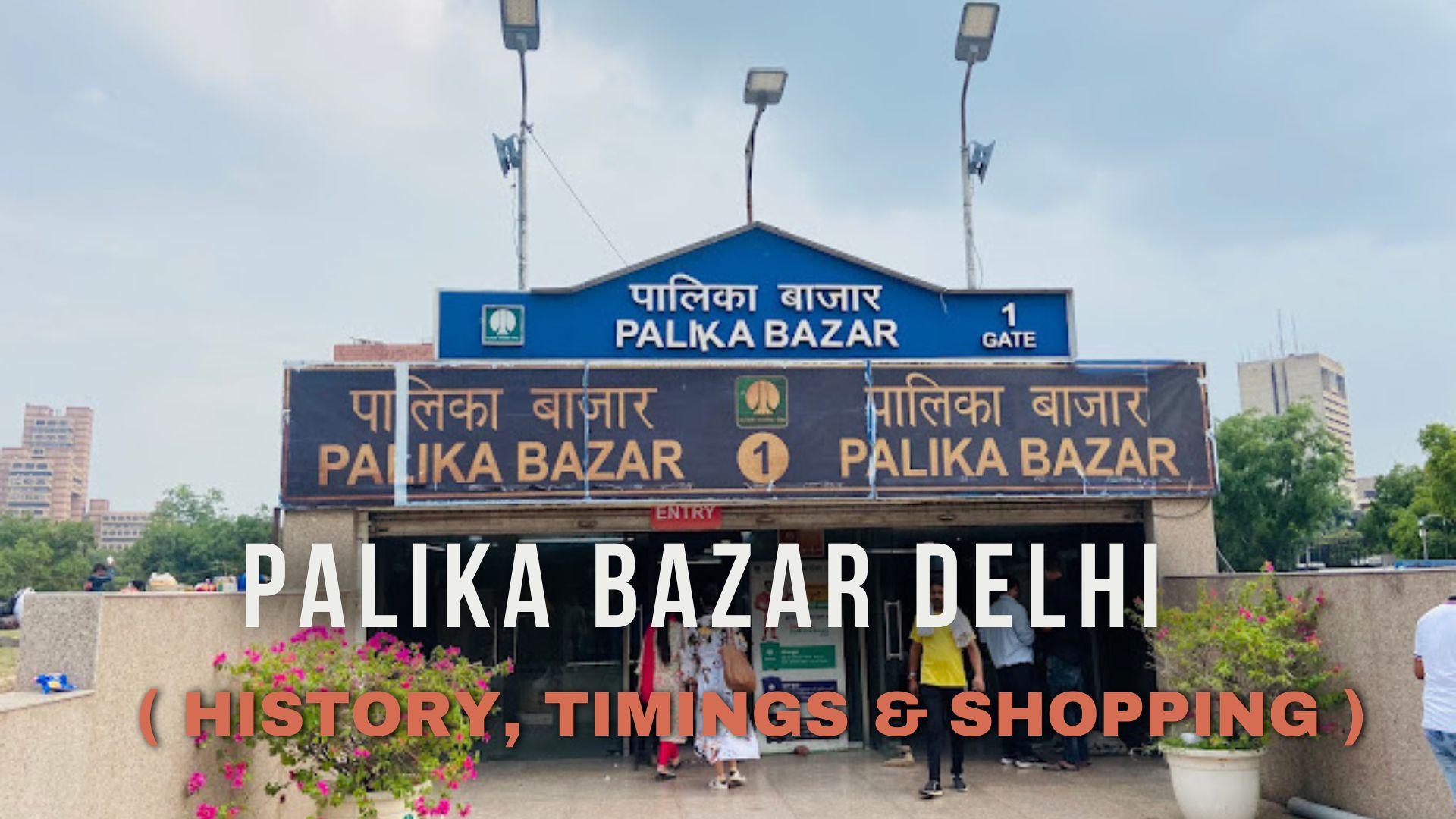 a group of people walking in front of palika bazar gate no. 1 delhi